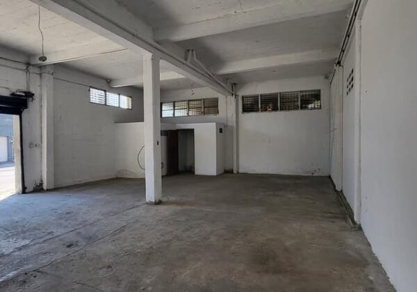 Bodega en alquiler con techo alto y cortina de hierro en Barrio Las Acacias, San Pedro Sula.