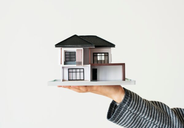Concepto de préstamo de vivienda con casa en miniatura sobre fondo blanco
